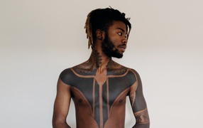 Темнокожий мужчина с татуировками на теле
