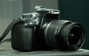 Фотоаппарат Canon 1100D лежит на столе