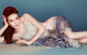 Английская актриса Элеонор Томлинсон лежит в платье на сером фоне