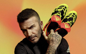 Football player David Beckham with Adidas sneakers in his hand