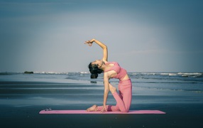 Girl doing yoga by the sea
