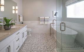 Gray bathroom with white bathtub and shower.