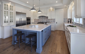 Large gray table in a spacious white kitchen