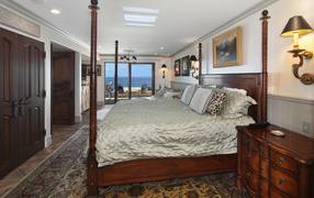 Большая деревянная кровать в спальне с видом на море 