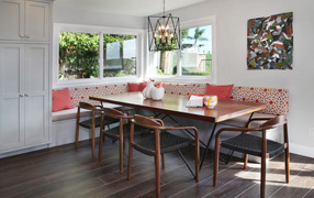 Большой деревянный стол и диван у окна в гостиной 