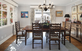 Большой деревянный стол в комнате с большими окнами