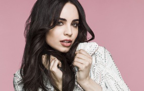 Длинноволосая актриса София Карсон на розовом фоне