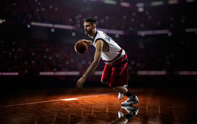 Мужчина баскетболист отбивает мяч на поле 