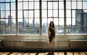 Популярная актриса Эмма Стоун стоит у большого окна