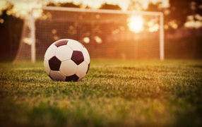 Футбольный мяч лежит на поле у ворот