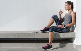 Спортивная девушка в костюме отдыхает после тренировки