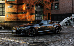 Черный автомобиль Audi RS E-Tron GT 2021 года у здания