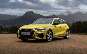 Желтый автомобиль Audi S3 Sportback 2021 года на фоне гор