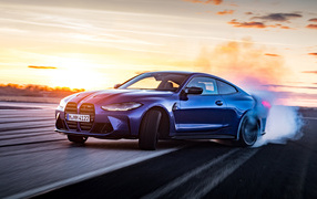 Синий автомобиль BMW M4 Competition  на фоне неба