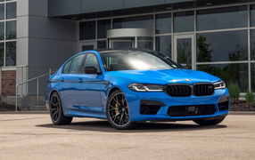 Blue BMW M5 car, 2021 in front of the building