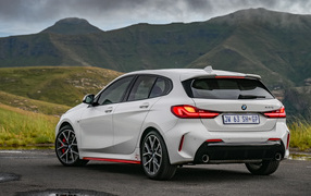 Белый автомобиль BMW 128ti 2021 года вид сзади на фоне гор