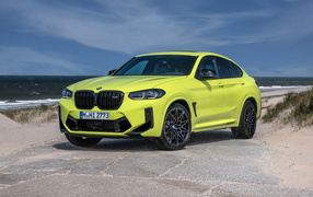 2021 BMW X4 M Competition yellow car against the background of the sea