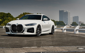Белый автомобиль BMW 4 Series Coupé M Sport Package 2021 года у города