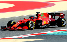 Красный гоночный автомобиль Ferrari SF21 2021 года на трассе