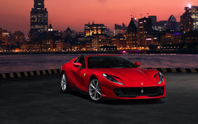 Красный автомобиль Ferrari 812 GTS  на фоне ночного города