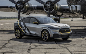 Серебристый Ford Mustang Mach-E, 2021 года у самолета