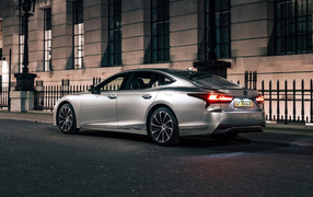 Серебристый автомобиль Lexus LS 500h 2021  года вид сзади