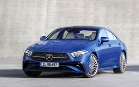 Синий автомобиль Mercedes-Benz CLS 350 AMG Line 2021 года на фоне серой стены