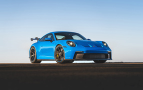 Синий автомобиль Porsche 911 GT3 2021 года на фоне неба