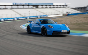 Голубой автомобиль Porsche 911 GT3 2021 года на стадионе