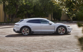 Серебристый автомобиль Porsche Taycan 4S Cross Turismo 2021 года у дома