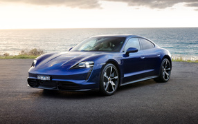 Синий автомобиль Porsche Taycan Turbo у моря