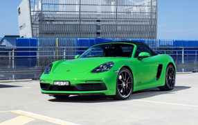 Green car Porsche 718 Boxster GTS in front of the building