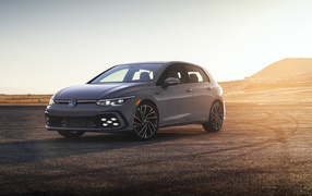 Серебристый автомобиль Volkswagen Golf GTI на фоне заката