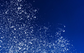 Белые брызги воды на синем фоне 