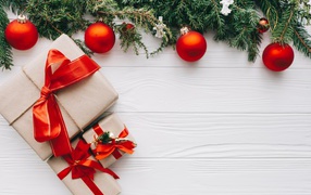 Подарки, еловая ветка и красные шары на Рождество 