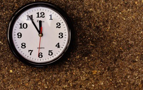 Большие черные часы висят на стене 