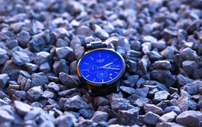 Голубые наручные часы лежат на камнях