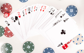 Колода игральных карт и фишки на столе в казино 