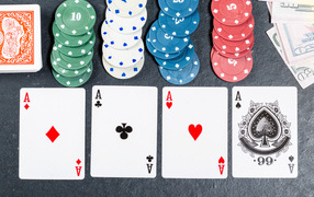 Четыре туза с фишками на сером столе