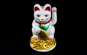 Японская фигурка манэки-нэко кошка на черном фоне