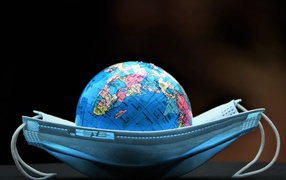 Медицинская маска и глобус на черном фоне