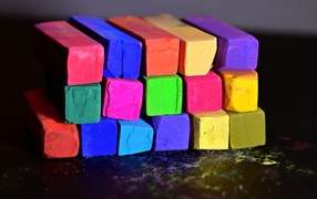 Multi-colored crayons for school on a black surface