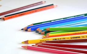 Разноцветные карандаши на белом столе 