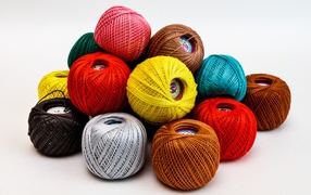 Разноцветные клубки пряжи на белом фоне 