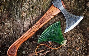 Старый топор с рисунком у дерева 