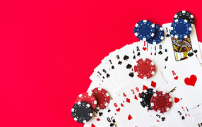 Карты для покера и фишки на красном фоне 