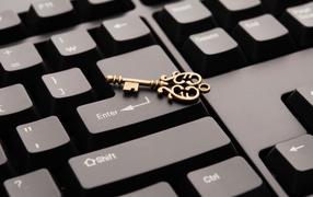 Золотой ключ лежит на черной клавиатуре