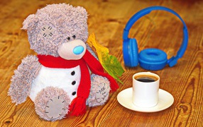 Игрушечный медведь с наушниками и чашкой кофе