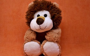 Игрушечный лев на фоне стены