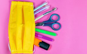 Yellow medical mask with handles and scissors on pink background